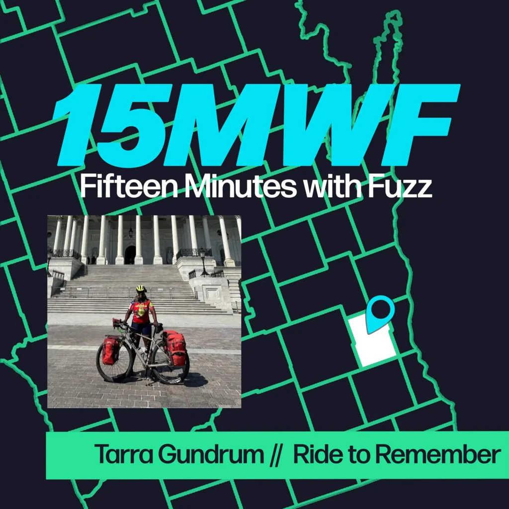 A contemporary graphic featuring “15MWF” in bold, bright turquoise letters at the top. Below it, the full name “Fifteen Minutes with Fuzz” is written in white. The background includes a map outline in green, with a highlighted area pinpointed in white and blue, indicating a specific location. At the bottom, there is a rectangular photo of a cyclist, Tarra Gundrum, standing with a loaded touring bike in front of a large, white, columned building. Below the photo, the text “Tarra Gundrum // Ride to Remember” is displayed in green on a black strip.