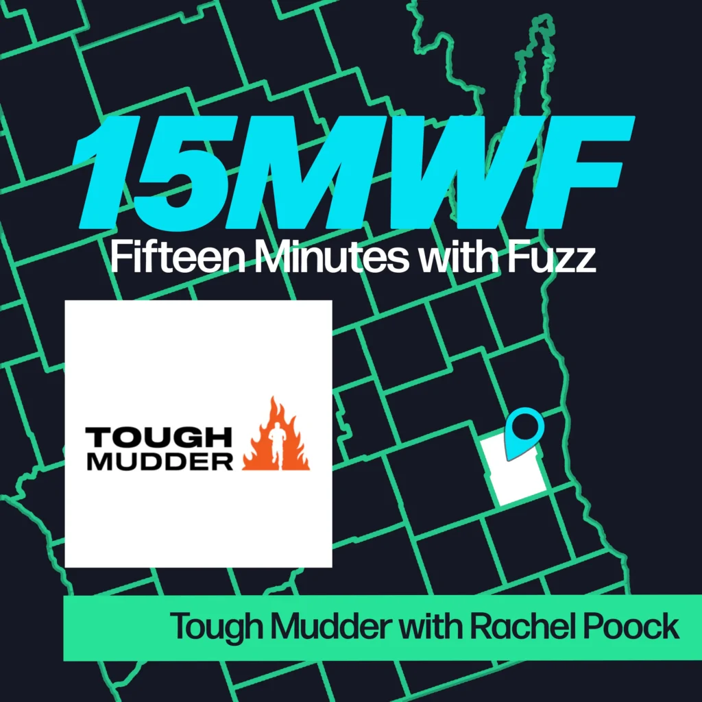 A promotional image for “Fifteen Minutes with Fuzz” featuring a map of Washington County, Wisconsin. The title “15MWF Fifteen Minutes with Fuzz” is displayed prominently at the top. Below it, there is an image of the Tough Mudder logo, which includes the text “TOUGH MUDDER” and a silhouette of a person running through flames. The text at the bottom reads “Tough Mudder with Rachel Poock.” A blue location pin is marked on the map indicating the event’s location.