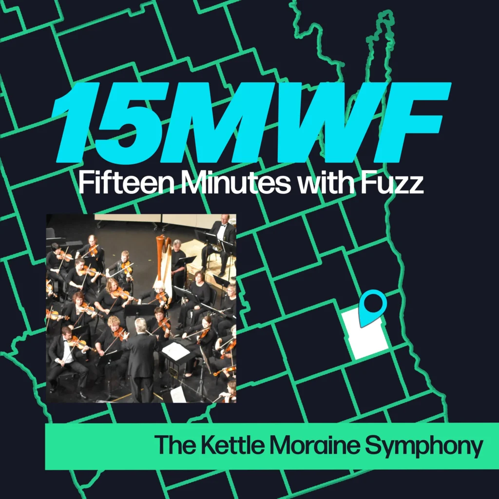 A promotional image for “Fifteen Minutes with Fuzz” featuring a map of Washington County, Wisconsin. The title “15MWF Fifteen Minutes with Fuzz” is displayed prominently at the top. Below it, there is an image of the Kettle Moraine Symphony Orchestra performing, with the text “The Kettle Moraine Symphony” at the bottom. A blue location pin is marked on the map indicating the event’s location.