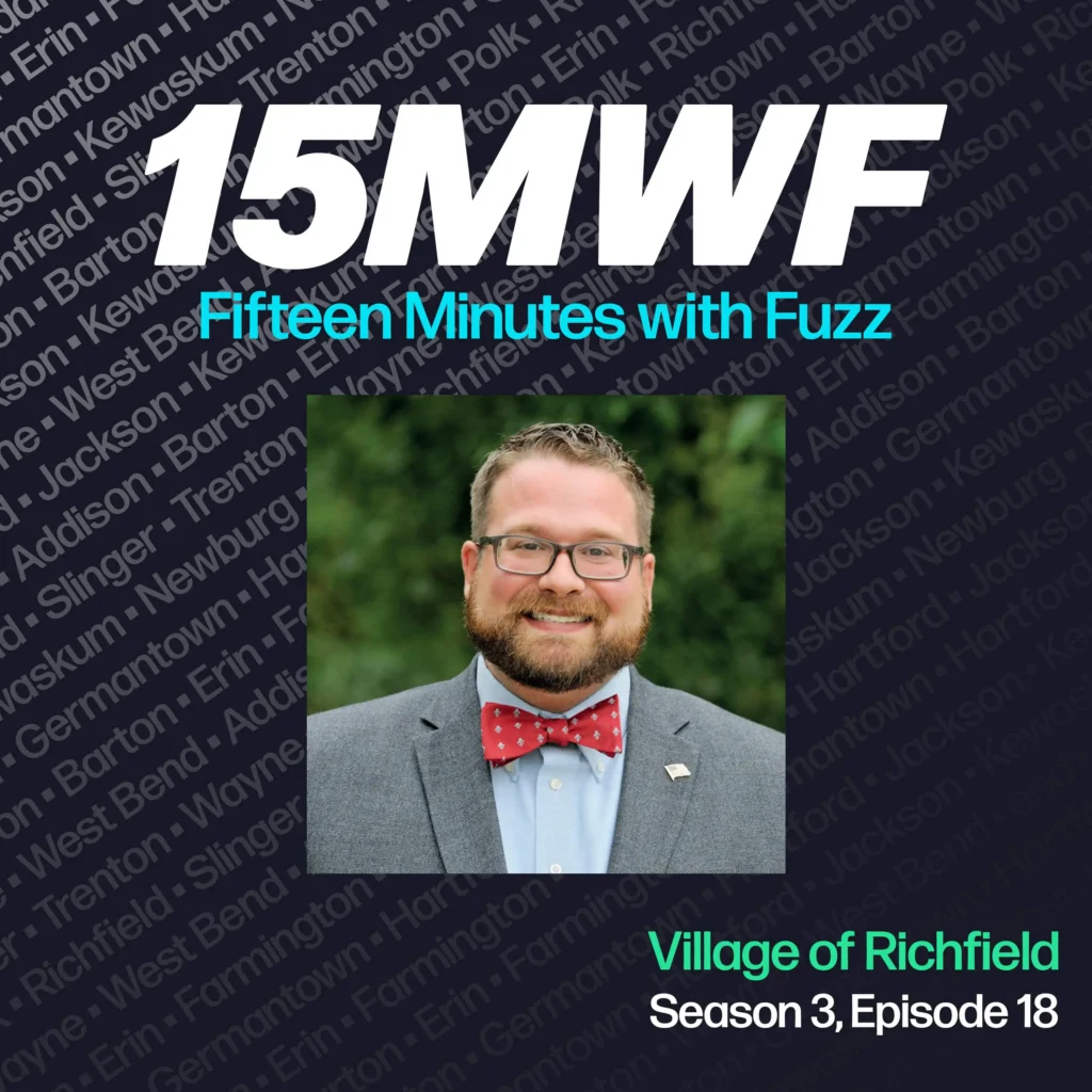 15MWF - Fifteen Minutes with Fuzz podcast cover art for Season 3, Episode 18 featuring Jim Healy from the Village of Richfield. The background includes names of various locations within Washington County, emphasizing the local focus of the podcast. Jim Healy is wearing a gray suit with a red bow tie and is smiling at the camera.
