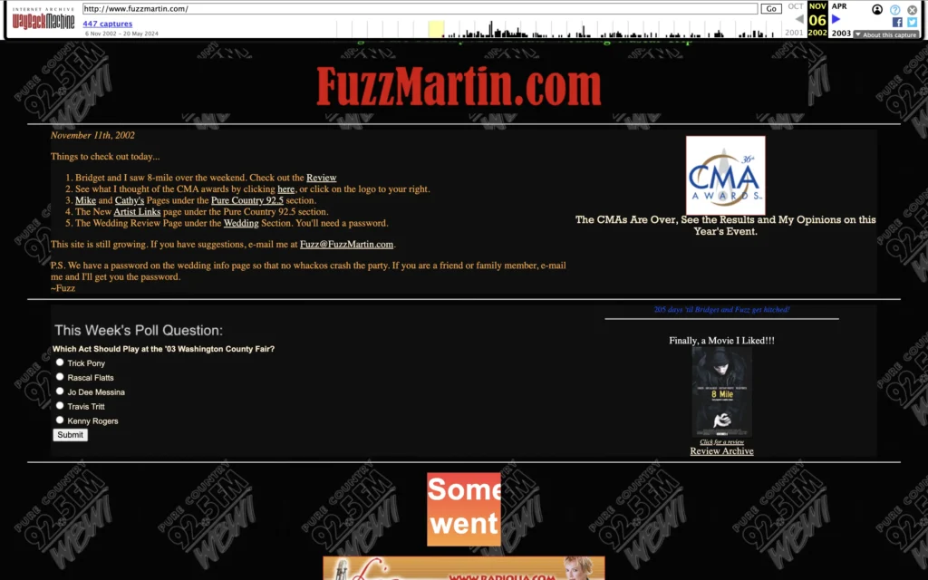 Screenshot of FuzzMartin.com from November 11th, 2002, captured via the Internet Archive’s Wayback Machine. The website features a black background with red and yellow text. The header displays “FuzzMartin.com” prominently in red. The content includes a list of updates such as a movie review of “8 Mile,” links to CMA awards coverage, and updates on Mike and Cathy’s pages under the Pure Country 92.5 section. There’s a note about the website still growing and a suggestion to email Fuzz at Fuzz@FuzzMartin.com for feedback. Additionally, there is a poll question asking which act should play at the ’03 Washington County Fair, with options including Trick Pony, Rascal Flatts, Jo Dee Messina, Travis Tritt, and Kenny Rogers. An image promoting the CMA Awards is also visible.