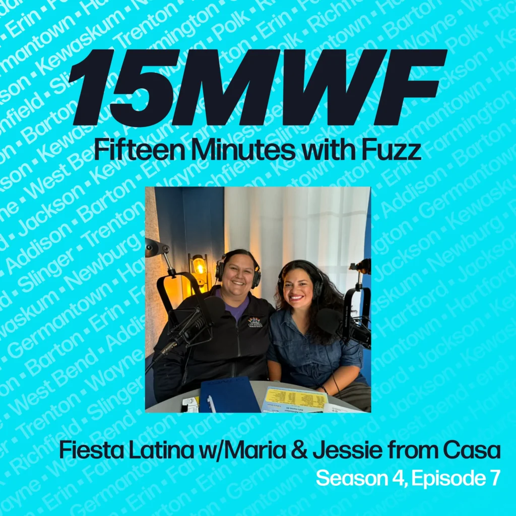 Square promotional graphic for ‘Fifteen Minutes with Fuzz’, Season 4, Episode 7, titled ‘Fiesta Latina with Maria & Jessie from Casa’. The graphic includes a central image of Maria and Jessie smiling at a podcast recording setup, surrounded by a border with town names in teal and blue text on a black background.