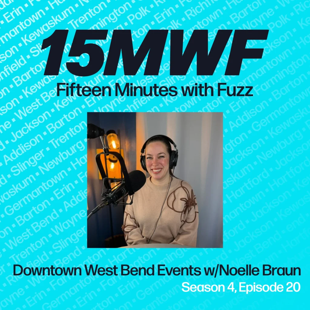 A promotional graphic for the Fifteen Minutes with Fuzz podcast. The large black text at the top reads “15MWF” with the subtitle “Fifteen Minutes with Fuzz” below it. The background is bright turquoise with repeated names of Washington County communities in light blue text. Centered is a photo of Noelle Braun smiling in front of a microphone, wearing headphones and a beige sweater with floral embroidery. Below the photo, the text reads, “Downtown West Bend Events w/ Noelle Braun, Season 4, Episode 20.”