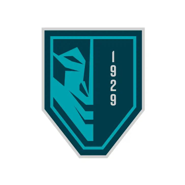 The logo of The Bend Theater, featuring a shield-shaped design with a teal outline. The left side of the shield contains a stylized geometric figure, and the right side features the number “1929” in vertical text, representing the year the theater was established. The background is a deep teal color.